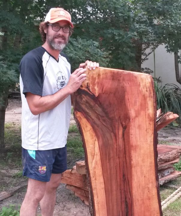 Daniel Baugh holding a slab of pecan that could one day be a fine piece of beautiful furniture.